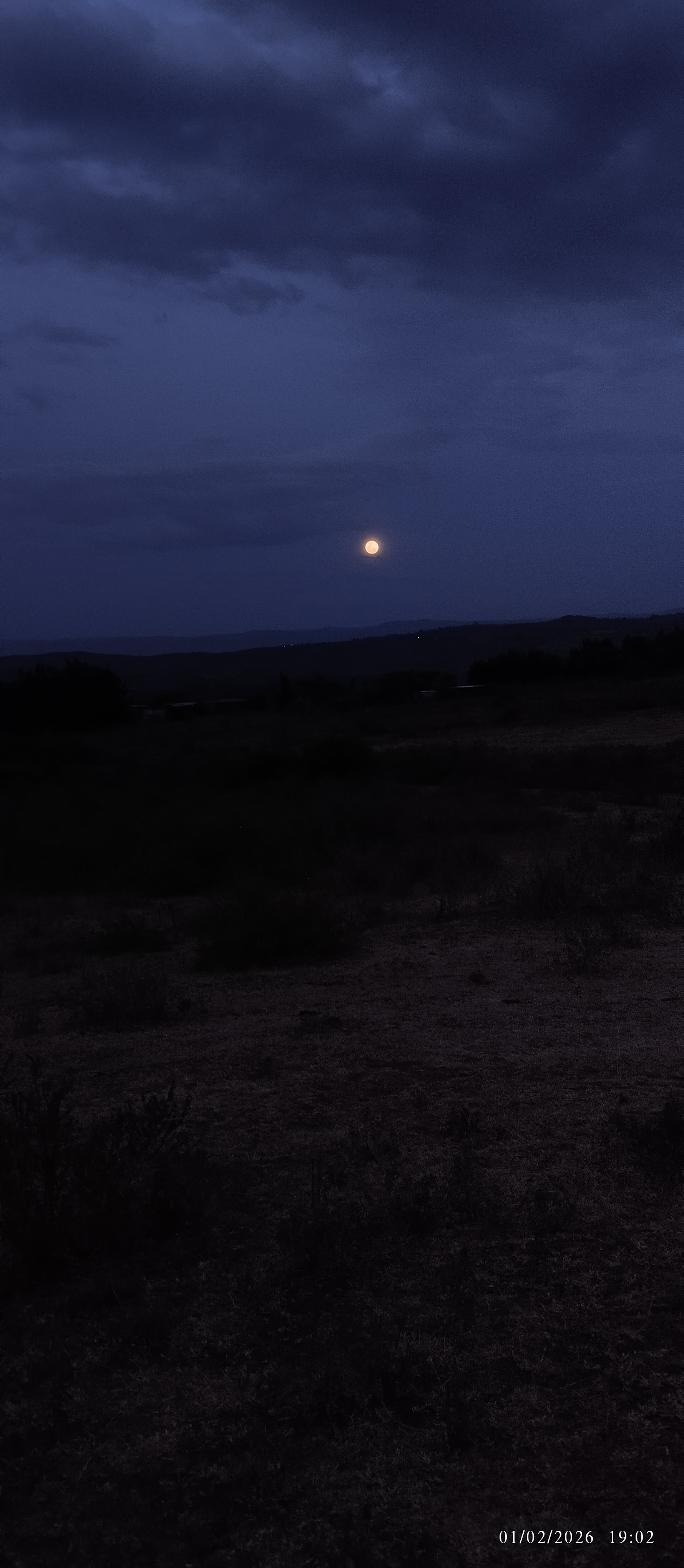 The full moon partially visible through cloud cover, 2026